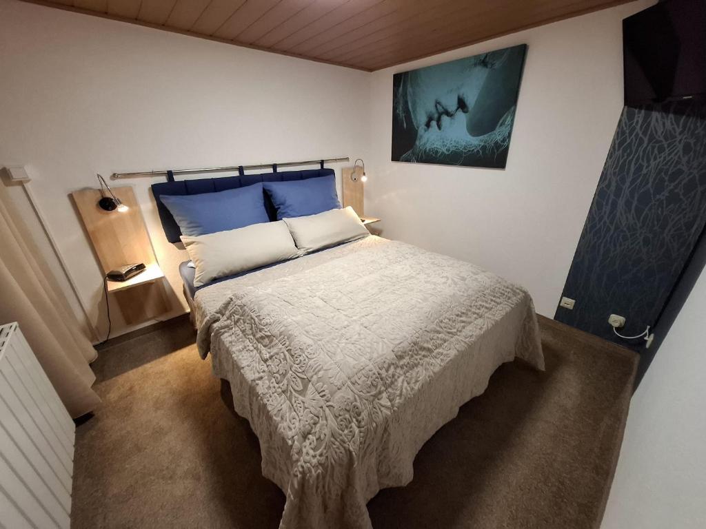 un dormitorio con una cama con sábanas azules y blancas en Ferienhaus im Pochwerksgrund in Suhl Goldlauter im Thüringer Wald, en Suhl