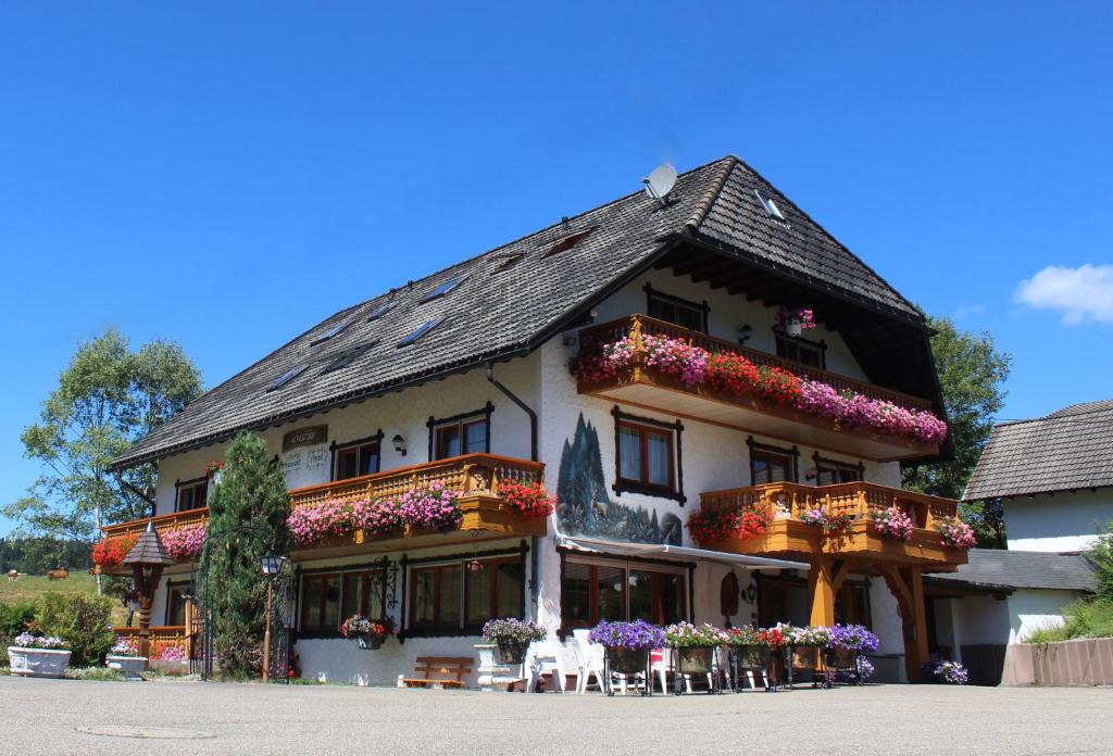 un gran edificio con flores en los balcones en Pension Altvogtshof, en Eisenbach