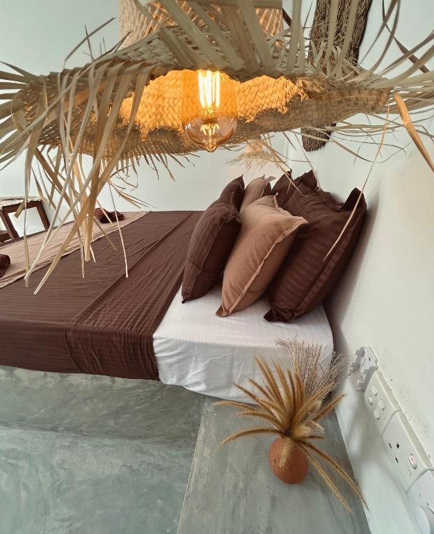 a bed with pillows on it next to a body of water at Bananas Mirissa in Mirissa
