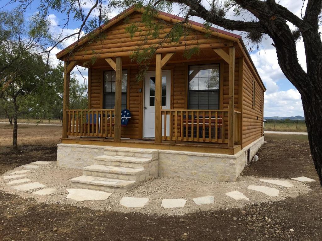 a small log cabin with a porch and stairs at Freedom River Cabin in Utopia
