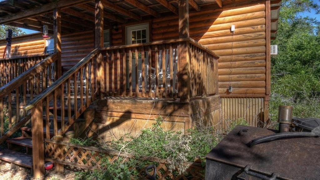 a wooden cabin with a staircase in front of it at Humming Bird Haven in Utopia