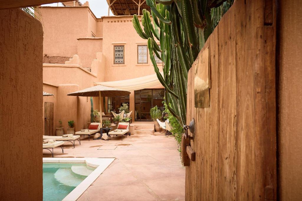 Un patio con piscina y una casa. en Riad Caravane, en Aït Ben Haddou