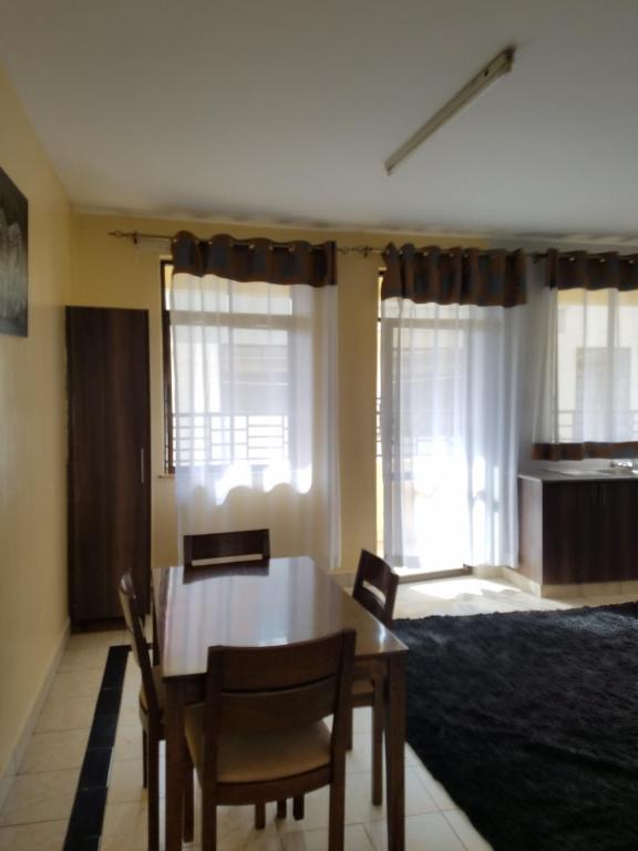 a dining room with a table and chairs and a bed at Almasi airport view apartment in Syokimau