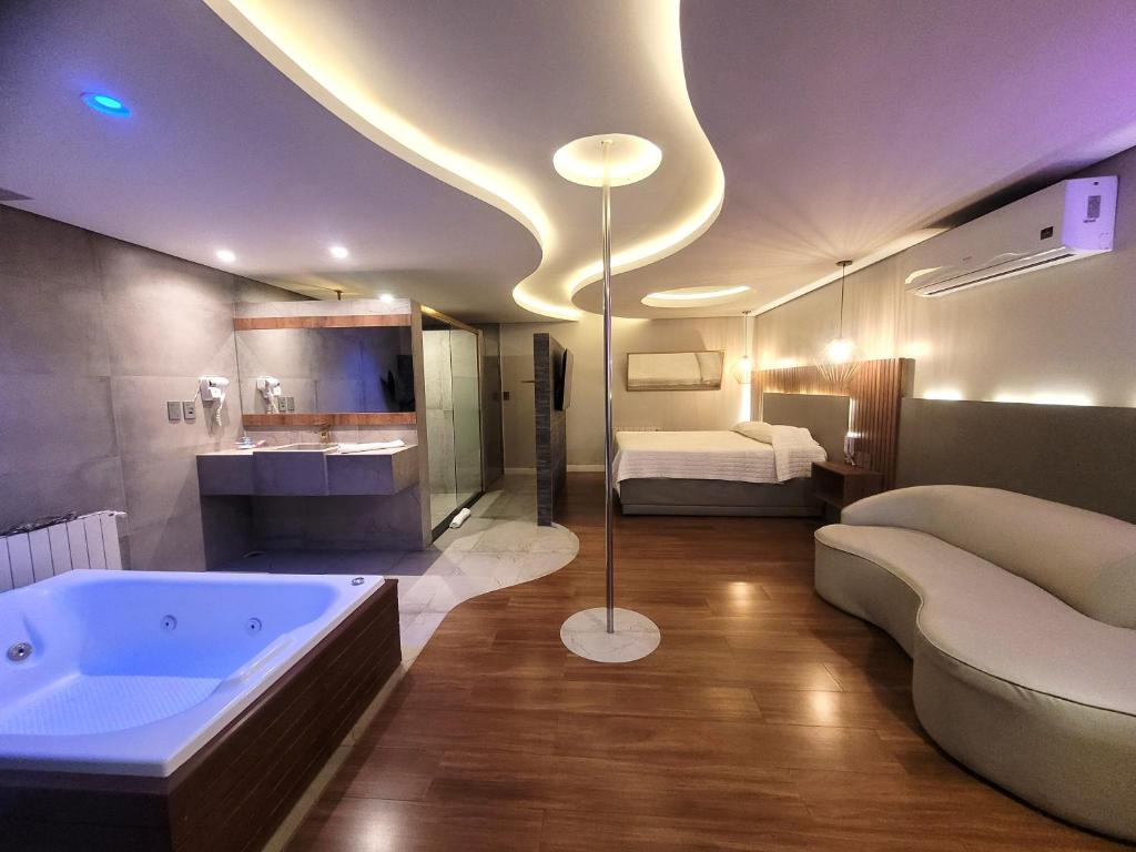 a large bathroom with a tub and a bed at Motel Daponti in Alegrete