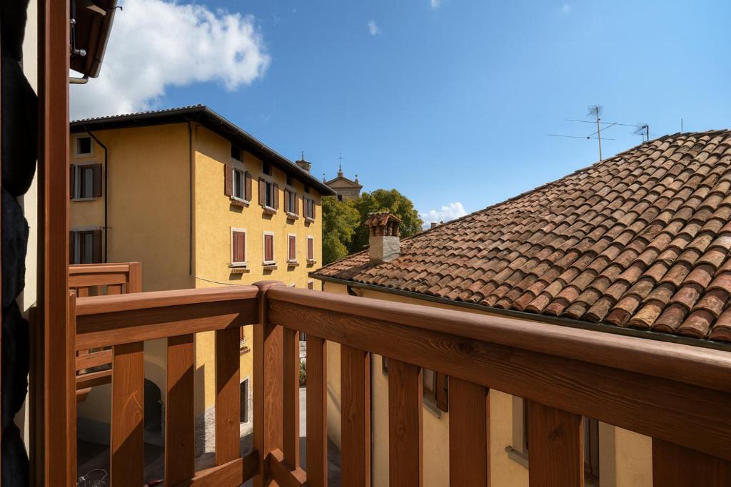 Un balcón de madera con vista a dos edificios. en Ca' Mia, en Borno