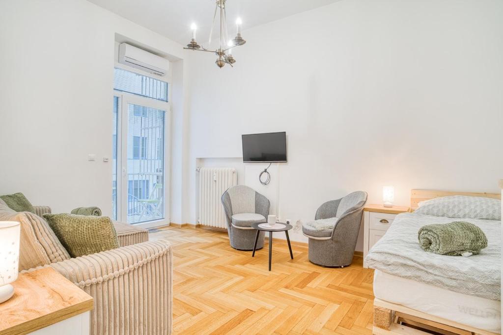 a bedroom with a bed and a couch and a tv at Charming Downtown Apartment in Otilia