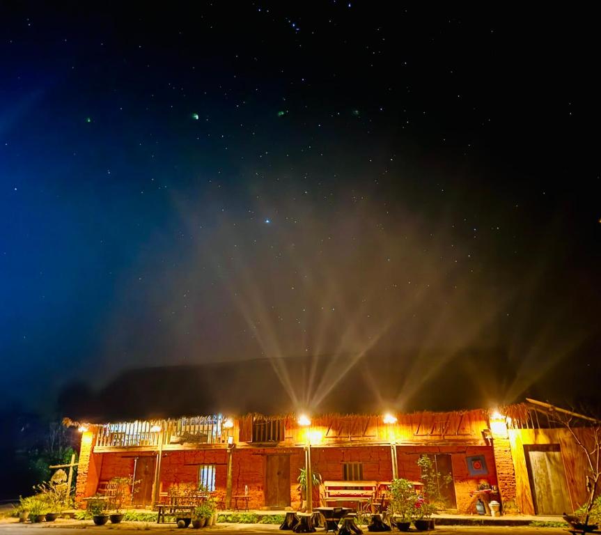 a building with lights in front of it at night at Quanba Taigoo - HomeStay in Ha Giang
