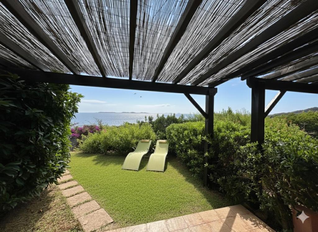 zwei Bänke unter einer Pergola mit Aussicht in der Unterkunft 8 ARBOUSIERS VILLA 16 in Bonifacio
