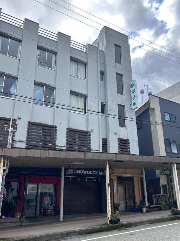 a building on a street in front of a building at 駅本ビル民宿4階 in Yuzawa