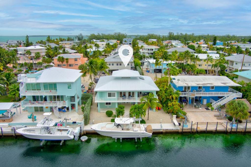 Una vista aérea de un complejo turístico con barcos en el agua. en Serene Home with Skiff Dockage & Access to Private Bayfront Beach, en Lower Matecumbe Beach