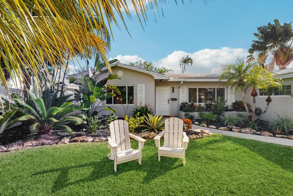 twee stoelen op een gazon voor een huis bij Once Upon a Beach Time in Pompano Beach