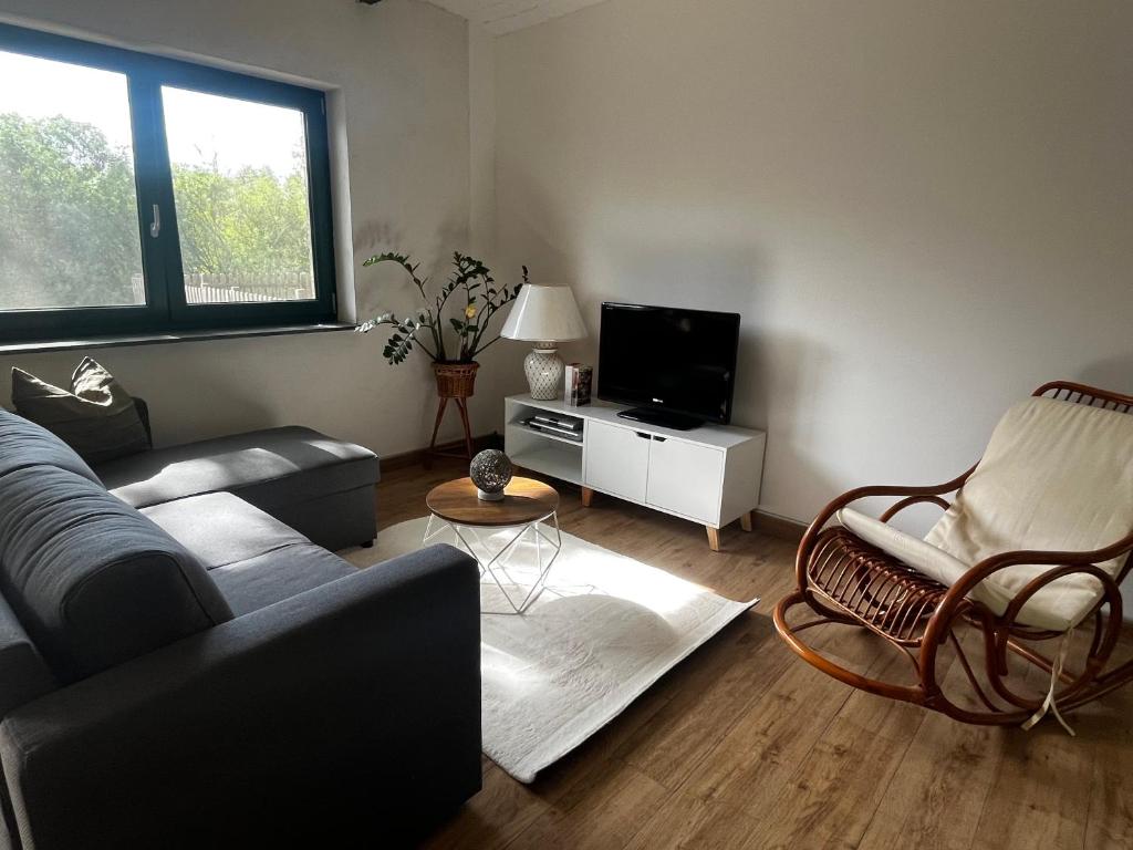 Una sala de estar con un sofá y un televisor. en Goldnebel, en Oranienburg