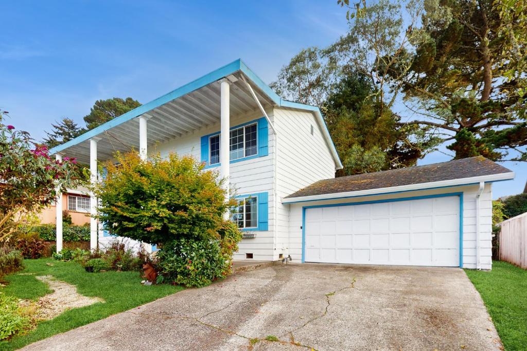 ein weißes Haus mit einem blauen Dach und einer Garage in der Unterkunft Eureka Charmer in Fields Landing