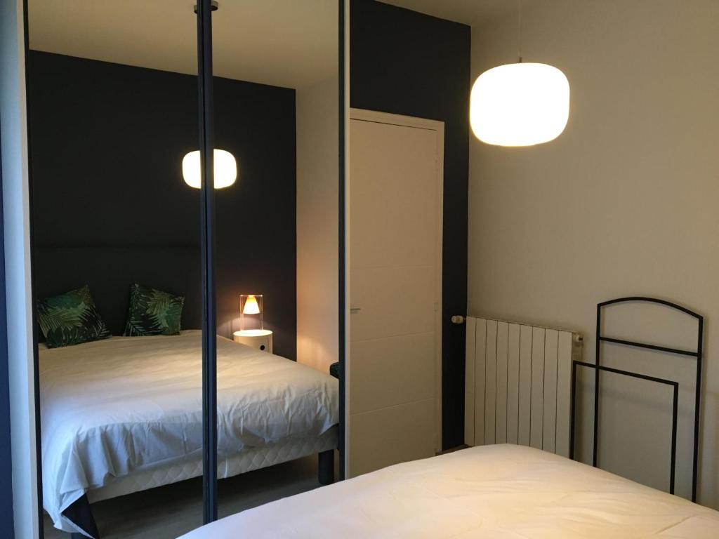 a mirror in a room with a bed and a bed at Le gîte de Marina in Rignac - Aveyron