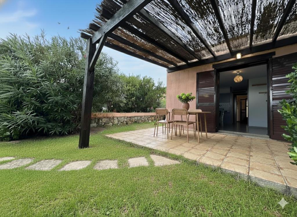 un patio avec une table et des chaises sous une pergola dans l'établissement 8 ARBOUSIERS VILLA 17, à Bonifacio