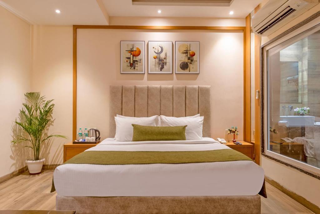 a bedroom with a large bed and a window at OPO Premium - Free Pickup delhi Airport in New Delhi