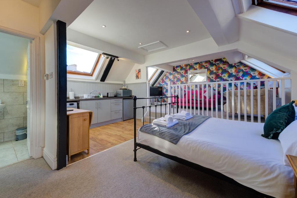 a bedroom with a bed and a kitchen at Stylish Studio in the Heart of Stamford Perfect Location in Stamford