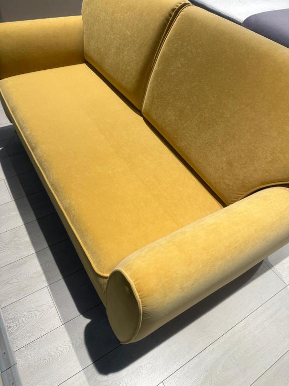 Tjaldstæðið í Tálknafirði býður upp á alla þjónustu في Talknafjordur: أريكة صفراء موضوعة على سطح الأرض