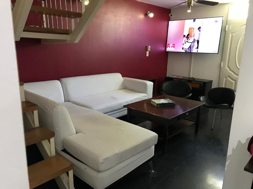 ein Wohnzimmer mit einer weißen Couch und einem Tisch in der Unterkunft Duplex SM in San Juan