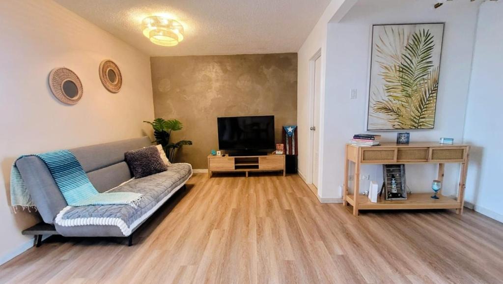 a living room with a couch and a television at Marina Views & Island Adventures: Fajardo Condo with Pool in Beltran