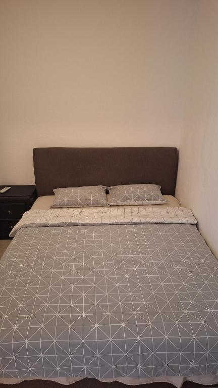 Un dormitorio con una cama con un edredón azul y blanco. en Simpi, en Pržno