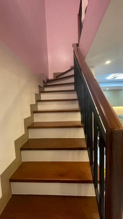 a staircase with brown and white stairs with wooden railings at Silang Guest house in Bangkal