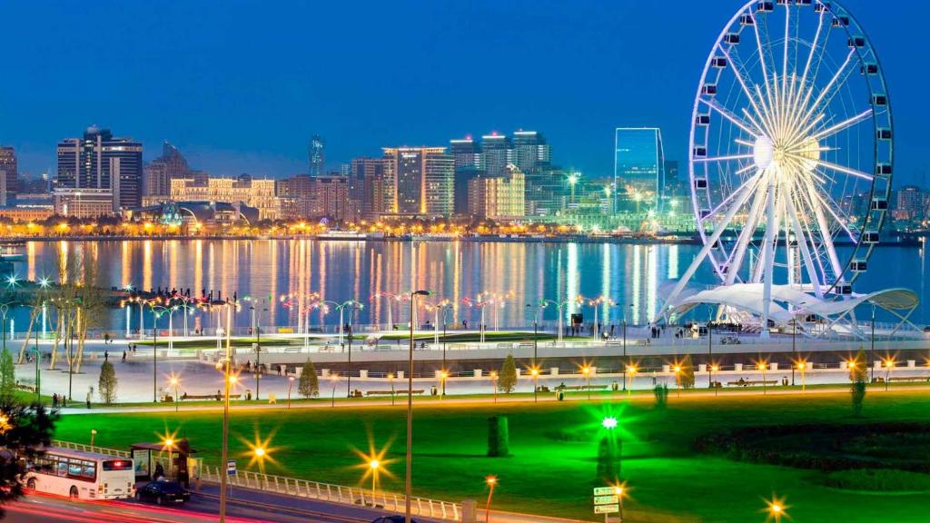 a ferris wheel in front of a city at night at Park Dedeman Baku in Baku