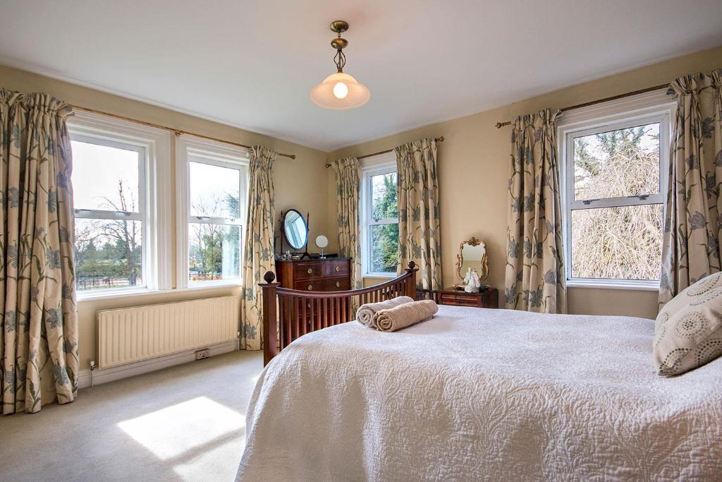 a bedroom with a bed and two windows at Garrane House in Croom