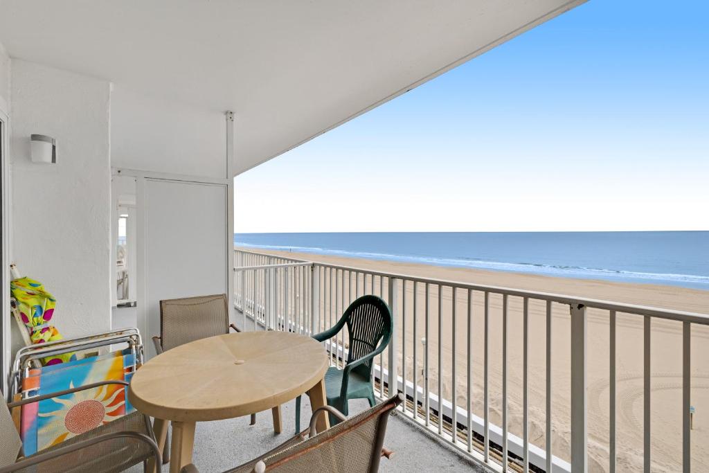 a balcony with a table and chairs and the beach at El Capitan 403 in Ocean City
