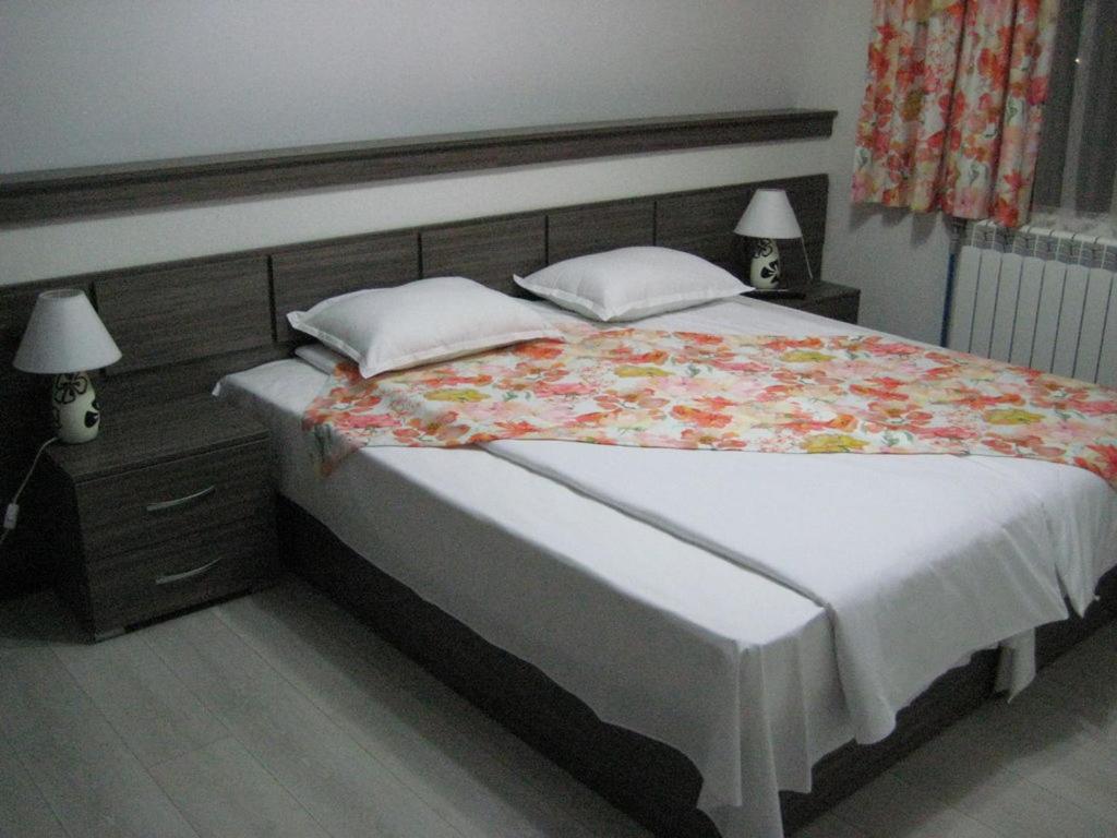 a bedroom with a large bed with a floral blanket at Къща за гости Семейство Петрови in Kalofer