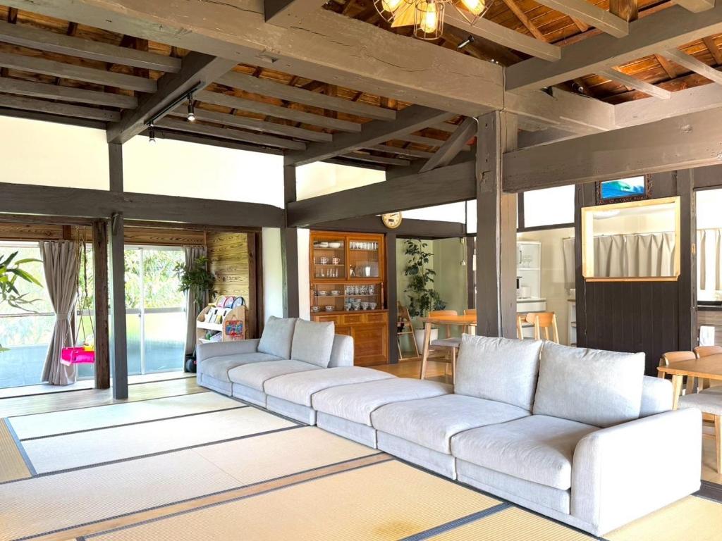 a living room with white couches and windows at yumigahama Eaglehouse in Minamiizu