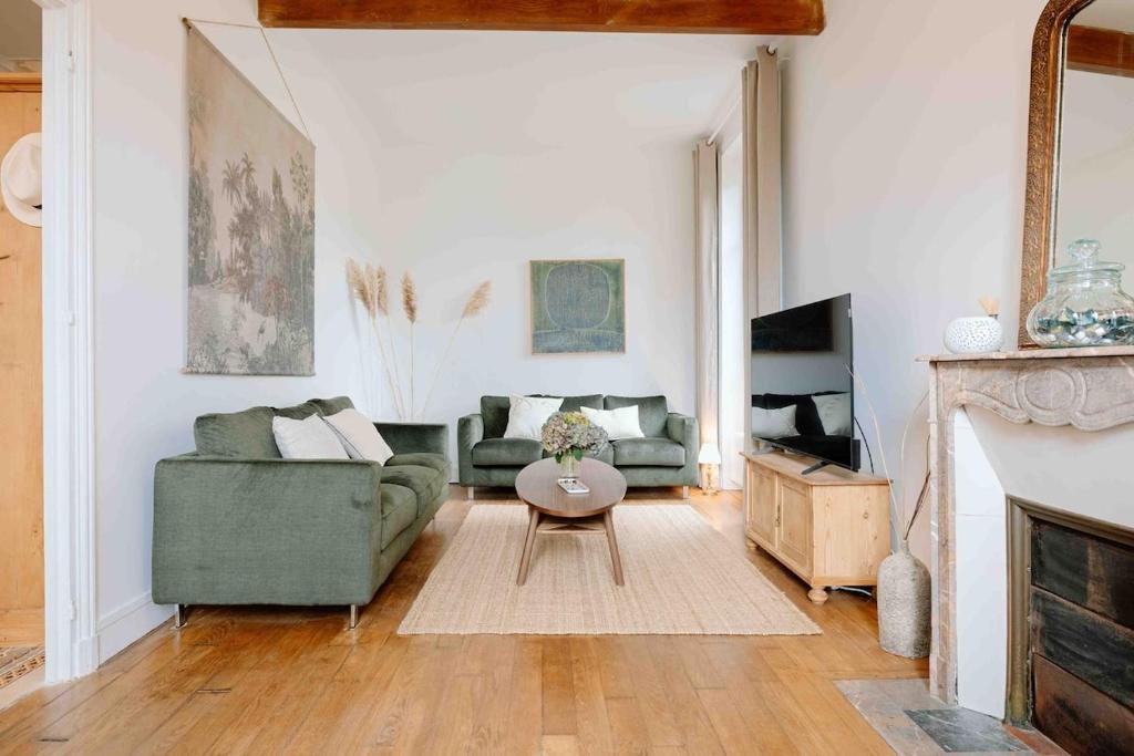 een woonkamer met een groene bank en een tafel bij Villa des Genêts in Saint-Pair-sur-Mer