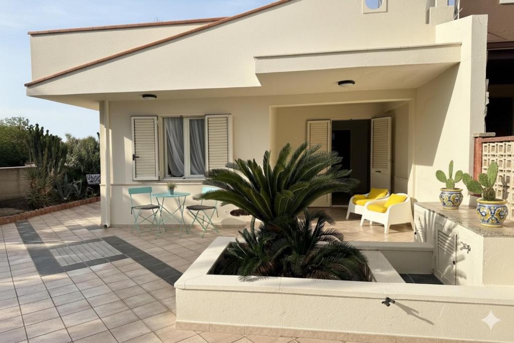 a house with a patio with chairs and plants at Casa Cycas in Santa Maria Del Focallo