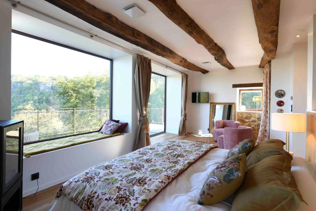 a bedroom with a bed and a large window at La Grange de Magdeleine in Salles-la-Source