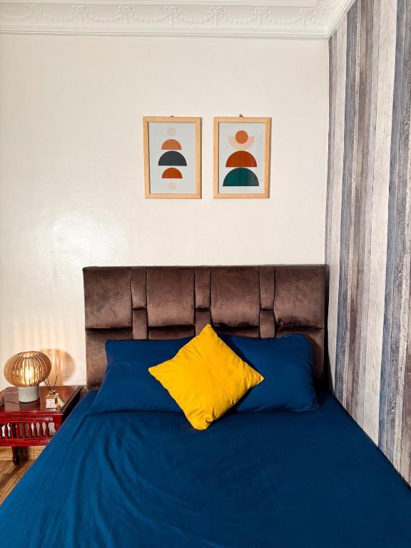 - une chambre avec un lit bleu et un oreiller jaune dans l'établissement Siinup Hostel, à Tiznit