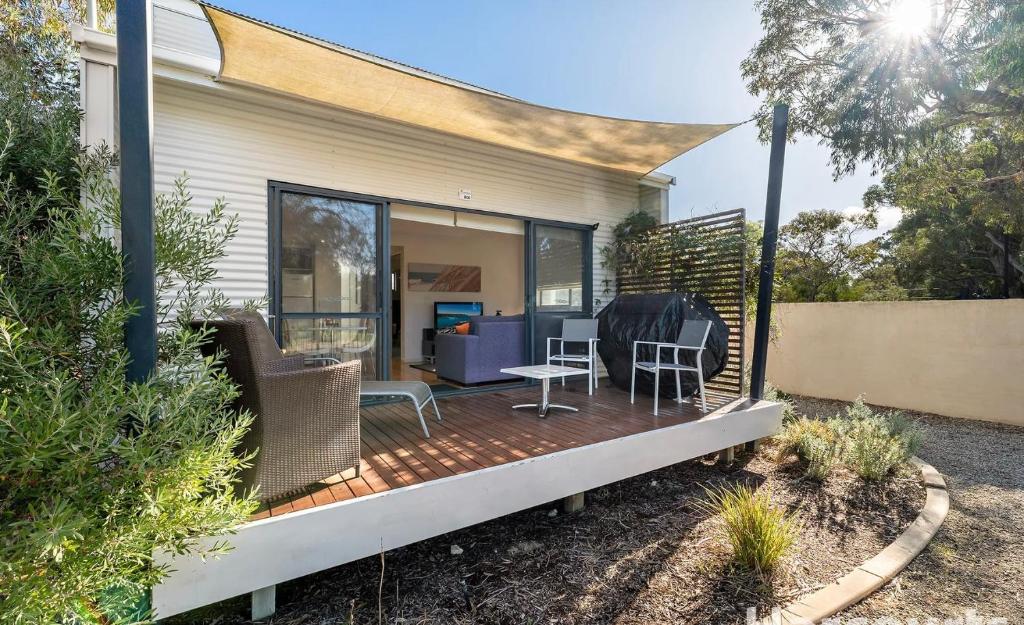a deck with chairs and a table on a house at Paradise at Footprints Preston Beach in Preston Beach