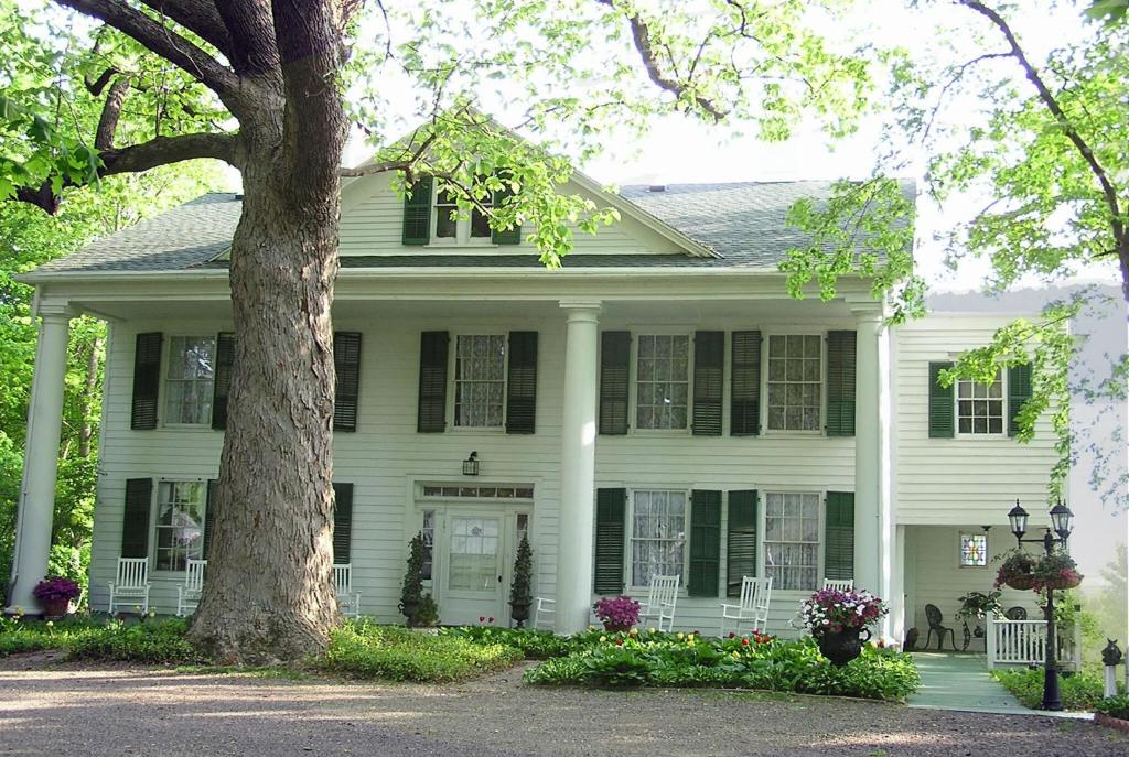 a white house with a tree in front of it at The Renwick Clifton House in Saugerties