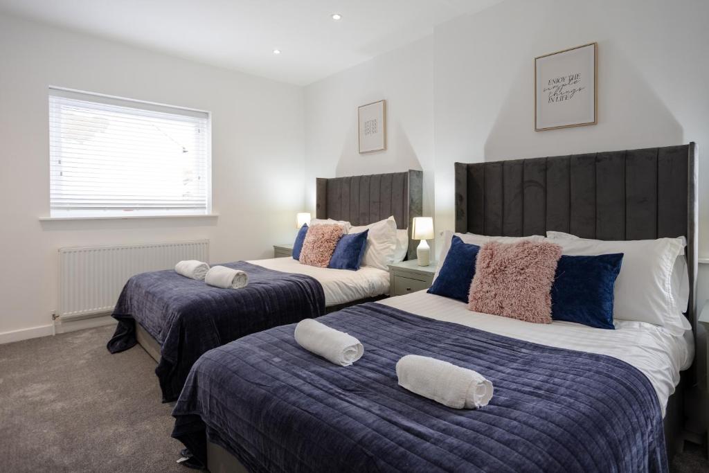 ein Schlafzimmer mit 2 Betten mit Kissen darauf in der Unterkunft Bespoke Apartments Near Cardiff City Centre Free Parking in Cardiff