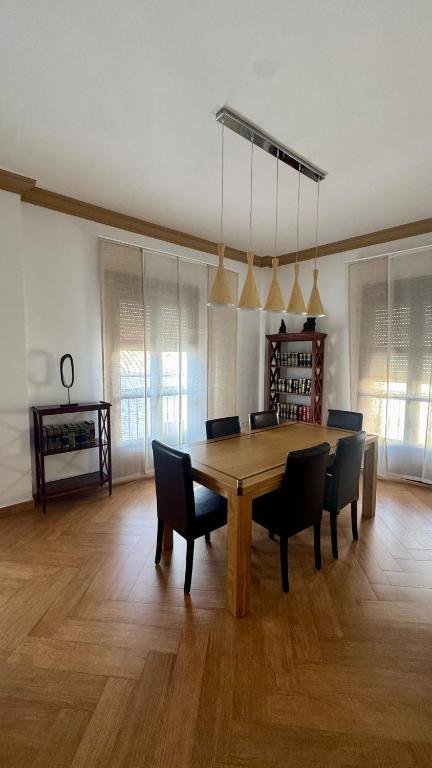een eetkamer met een houten tafel en stoelen bij Galteo Remedios in Ronda
