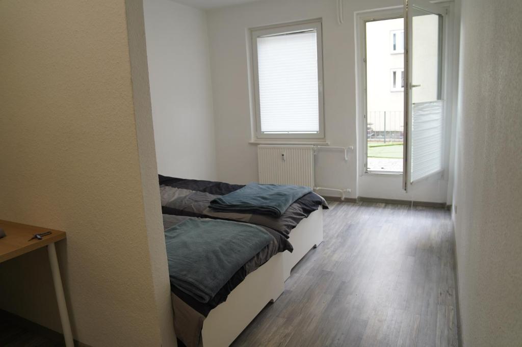Un dormitorio pequeño con una cama y dos ventanas. en Ihr Premium-Zuhause auf Zeit Komfortabel Wohnen in Bestlage, en Hannover