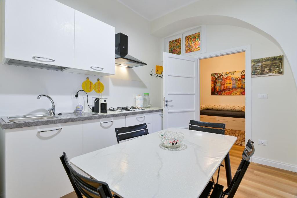 a kitchen and dining room with a white table and chairs at Residenza La Donzella - Appartamento bianco in Campobasso