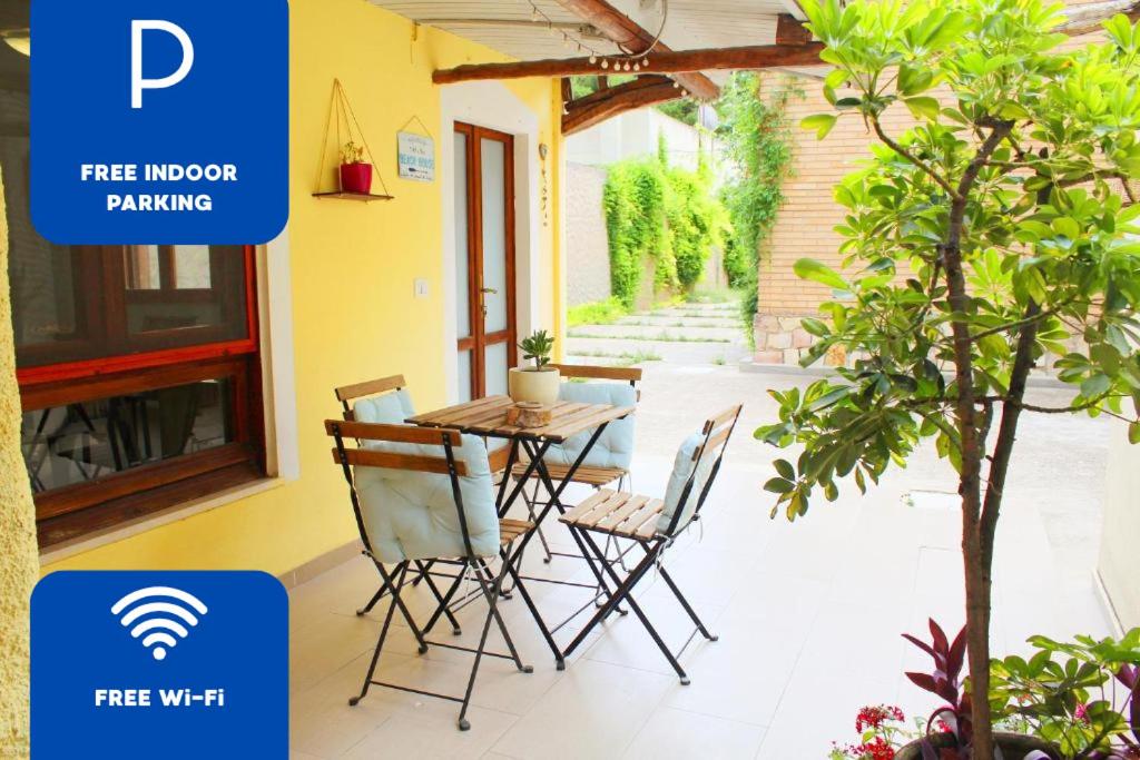 d'une terrasse avec une table, des chaises et un arbre. dans l'établissement S’alba Noa, à Quartu SantʼElena