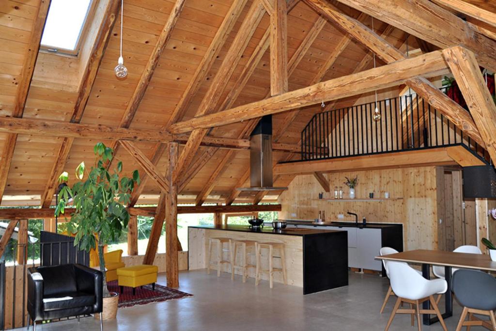 a large kitchen with wooden ceilings and tables and chairs at Ferienwohnung Reichart in Tannenbach