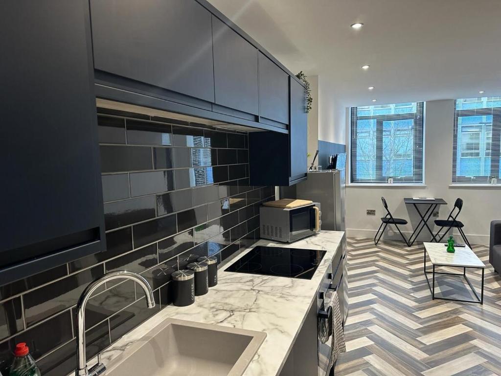 une cuisine avec un évier et un plan de travail dans l'établissement The Fortis Apartments - 1 Bed - WIFI - Videocom Entry - Close to Bus & Train Stations - Professionals, Contractors & Tourist Ready, à Peterborough