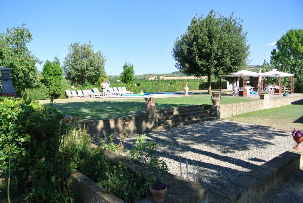 einen Garten mit einem Pool, Stühlen und Bäumen in der Unterkunft I Profumi Dell'Orto in La Sabatina