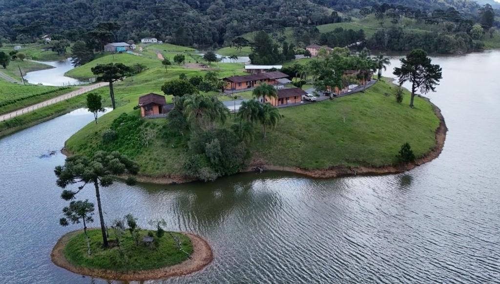 an island in the water with a house on it at Chalés Paraíso das Ilhas - Alto Cedros. in Rio dos Cedros