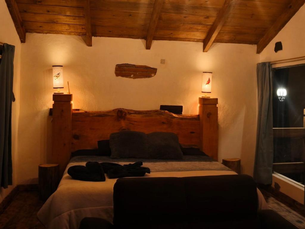 a bedroom with two beds and two lights on the wall at Cedrito in Mineral del Chico
