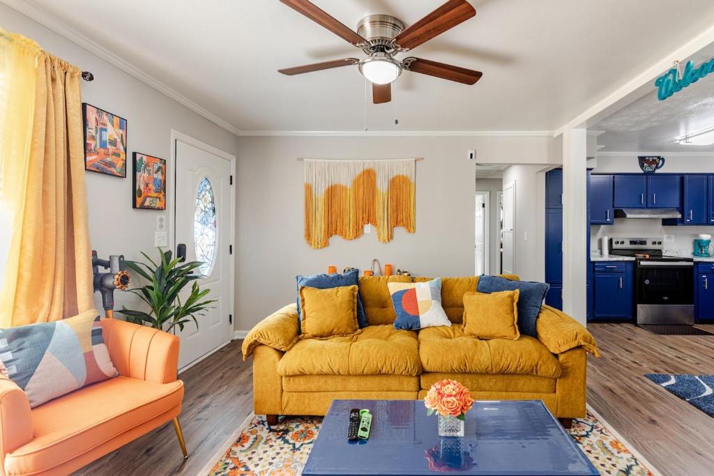 a living room with a yellow couch and a ceiling fan at Colorful & Cozy 3 Bedroom in Columbus in Columbus