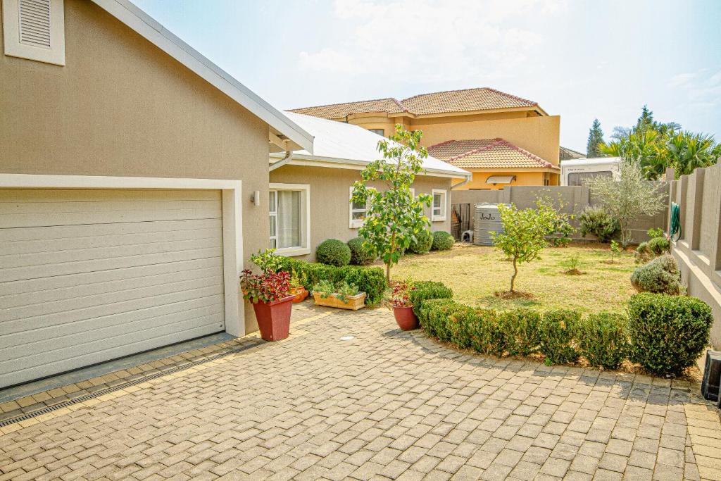 ein Haus mit einer Auffahrt mit einer Garage in der Unterkunft Fourways Home, Away From Home in Chartwell