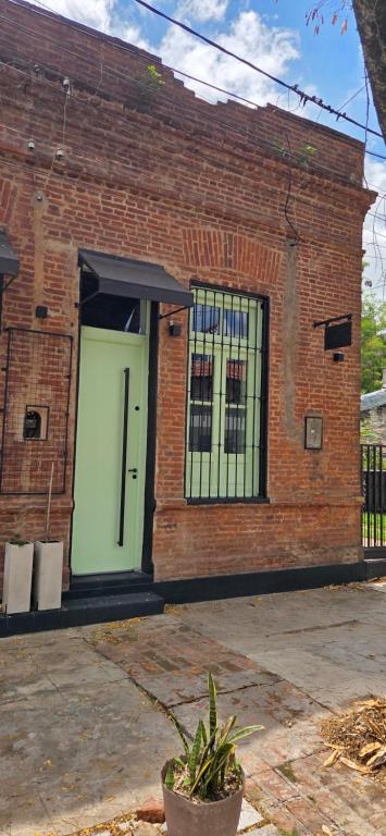 a brick building with a green door and windows at Pipa Alquiler Temporal in Resistencia